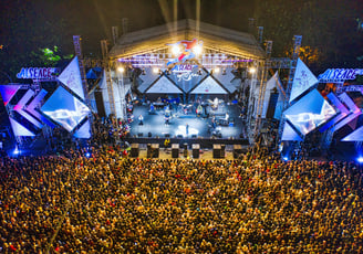 a large crowd of people standing around a stage