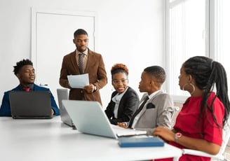 a man in a suit and tie is standing in front of a group of people