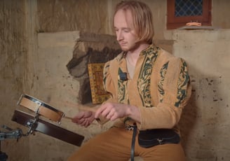 a man in a yellow shirt playing drums