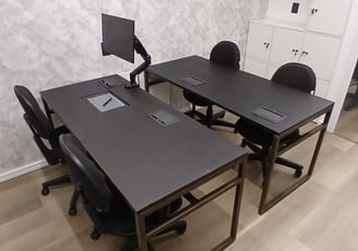 a desk with a computer monitor and a monitor