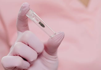 a person in a gloved hand holding an implant