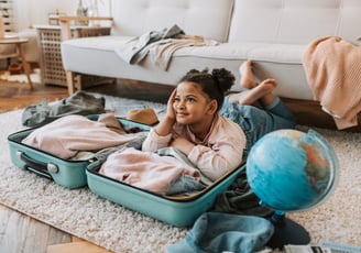 a young girl sitting on a rug in a living room