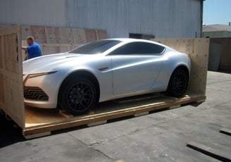 a car is being loaded into a custom crate