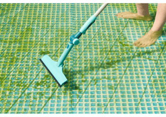 Pool tech vacuuming derbis during green to clean pool service maintenance
