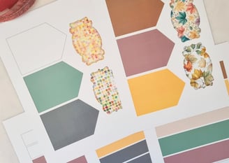 Colorful craft paper sheets featuring hexagonal shapes in muted tones and cutouts for card making