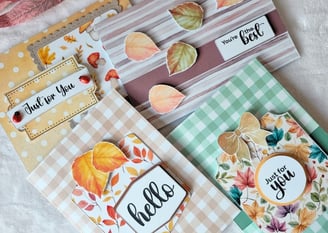 A collection of four handmade greeting cards with autumn themes. The colors are warm and inviting.