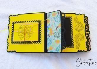 Elegant handmade photo album featuring yellow and black scalloped layers. Center has a floral illust