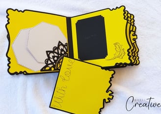 Bright yellow handmade album with scalloped edges, featuring black floral cutouts, a "With Love" mes