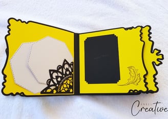 Open handmade album with a black and yellow theme on a white background. Left side features geometri