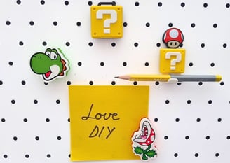 Magnetic board features colorful Mario-themed magnets: Yoshi, mushroom, and piranha plant. A yellow