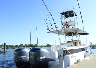 a boat docked at a dock with fishing rods