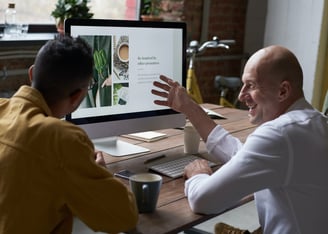 a man and a woman are sitting at a desk