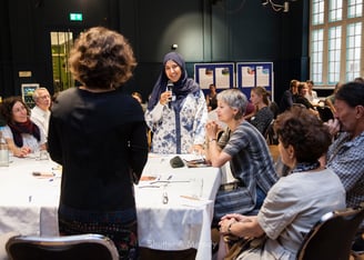 Eine muslimische Frau stellt dem Moderator während eines Workshops eine Frage.