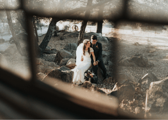 a bride and groom standing in front of a window