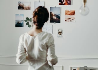 Femme regardant ses photos affichées sur le mur