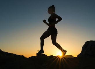 a woman running on a rocky mountain trail