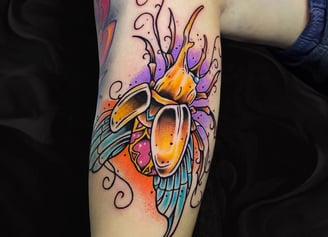 a neaotraditional tatto about an egiptian scrab made with gold and gems