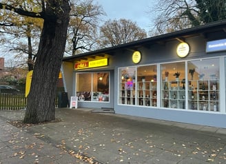 a store front of a store with a clock on the front of it