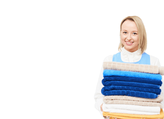 a woman holding a stack of towels in commercial laundry.