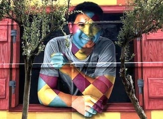 Mural colorido de Eduardo Kobra retratando uma pessoa com o rosto e braços cobertos por padrões