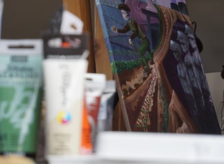 A painted canvas in a cubist or constructivist style depicting agriculture is displayed in focus.