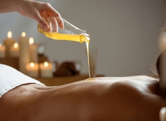 Massage huiles BIO sur le dos d'une femme - Massage Ayurvédique