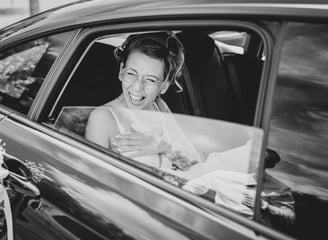 a bride laughing in a car
