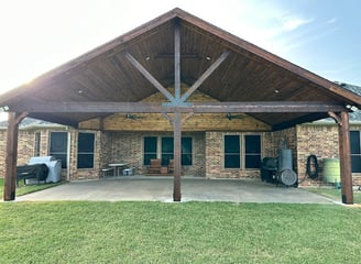 Larged covered patio with a vaulted wooden ceiling.