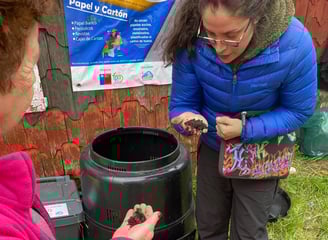 Equipo EcoRumbo enseñando a la comunidad uso de compostera en educación ambiental.