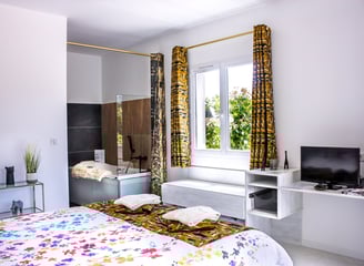 Bedroom with bathroom and toilet, television, air conditioner and pool view at Domaine Des Lucques