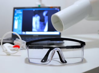 a laptop computer and a pair of X ray glasses on a desk