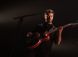 a man playing a Gibson red guitar in a concert