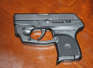 Ruger LCP with laser laying on a wood table