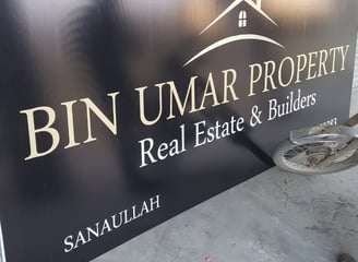 a man is working on a sign for bin umar Property