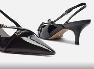 a pair of black shoes with a gold buckle