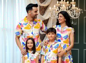 a family of three standing in front of a chandelier