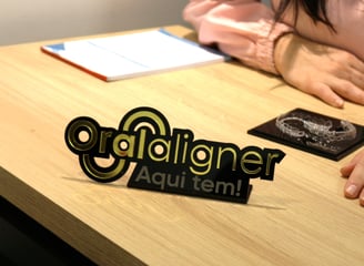 a woman sitting at a table with a invisible teeth aligner in front of her