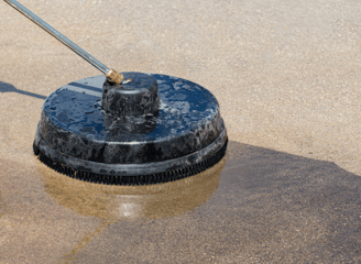 a person using a pressure to clean a driveway