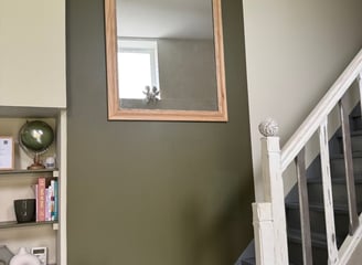 Miroir à cadre bois clair sur mur vert olive et escalier repeint