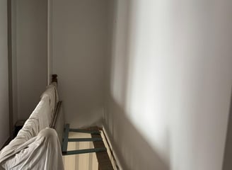 Mur d’escalier blanc uni avant pose de papier peint