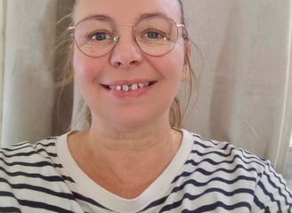 Femme blonde avec des lunettes et un pull rayer noir et blanc