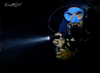Advanced Scuba diver diving with a torch during a night dive at Gili Trawangan