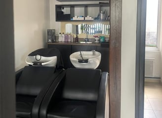 Zone de soin capillaire avec bacs de lavage professionnels chez X Tension NC, pour une expérience d