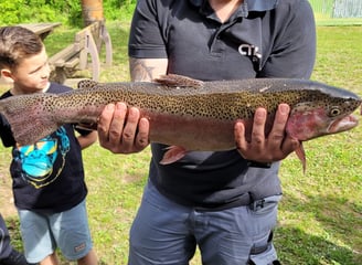 a man holding a fish on a field