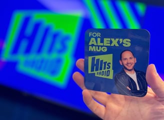 A Hits Radio drinks coaster that says 'for Alex's mug' on it.