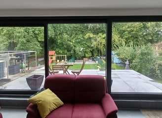 big panorama window, a couch in a living room with a view of the backyard