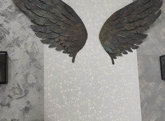 Ailes décoratives métalliques brun foncé sur mur gris clair