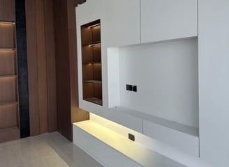 a living room with a white entertainment center and a large entertainment center