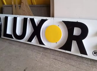 a large white sign with a yellow and black logo