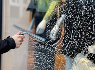 Nettoyage de la vitrine de la boutique Léo et Ugo à Rouen par M & M Services Pro avec une raclette